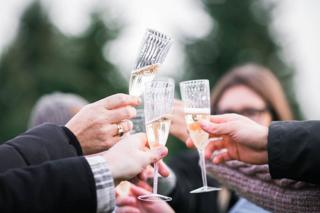 people celebrating by toasting with glasses of champagne